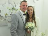 Brautpaar Denise und Nikolai Müller Brautpaar Denise und Nikolai Müller, Mann im grauen Anzug, Frau in weißem Kleid mit Blumenstrauß